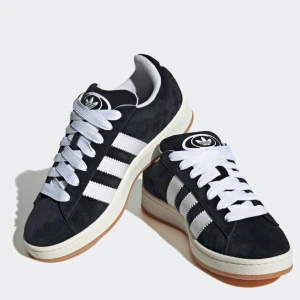 Adidas Campus 00s svart/vit sneakers - Adidas Campus 00s sneakers i svart mocka med vita detaljer storlek 37 1/3 . Dessa skor är helt nya och aldrig använda eftersom att de var för stora för mig, alltså helt nytt och fräscht skick med lappen kvar på skorna, löp och köp!😊💕