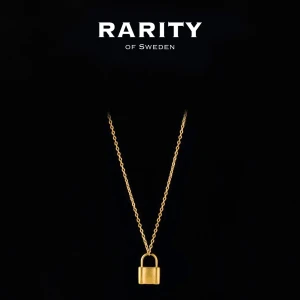 Lock Necklace - Gold: Guldigt halsband med lås från Rarity - Stilrent halsband i guld från Rarity of Sweden med ett coolt hängsmycke i form av ett lås. Kedjan är tunn och elegant, perfekt för att ge din outfit en trendig touch. Passar dig som gillar unika detaljer och modern design.