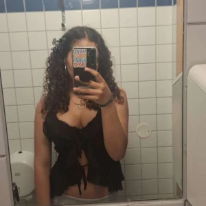 Svart volangig blus från Amisu - Supersöt svart blus från Amisu med volanger och knyt framtill. Blusen är ärmlös med tunna axelband och har en sthlm look med flera lager av volanger som ger en romantisk vibe. Perfekt att styla med jeans eller kjol för en trendig look.        Om due intresserad så kan du möta mej vid Värmdö så fixar vi swich och tröjan där🙂