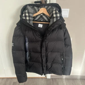 Burberry jacka - Säljer en svart dunjacka fràn Burberry, storlek M. Armarna är avtagbara sa jackan kan bli till en väst. Fraktar samma dag!