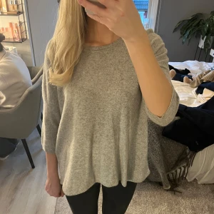 Grå stickad tröja med trekvartsärm - Grå finstickad tröja med tre kvartärm🤩 superfin kvalité i bra och fint matreal🤩materialet är 48% merino ull 30% viscose 15%nylon och 7% cahsmere 