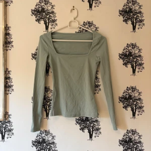 Ljusgrön långärmad topp från SHEIN - Snygg ljusgrön långärmad topp från SHEIN med fyrkantig halsringning. Modellen är slim och sitter snyggt mot kroppen. Tillverkad i mjuk bomullsmix som är skön att ha på sig. Perfekt att styla med jeans eller kjol för en clean look.