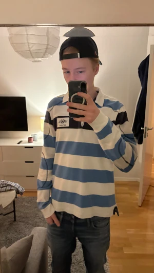 Randig rugbytröja Henri Lloyd blå/vit - Säljer en klassisk rugbytröja från Henri Lloyd i storlek M. Tröjan har breda blå och vita ränder, krage och knäppning vid halsen. Broderad logga på bröstet och långa ärmar. Bara att höra av er vid frågor eller funderingar!😊