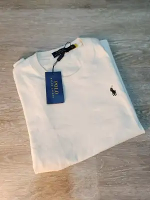 Vit t-shirt från Polo Ralph Lauren med klassisk rund hals och korta ärmar. T-shirten har den ikoniska broderade loggan i svart på bröstet och är gjord i mjuk bomull. Perfekt basic med stilren design och snygg passform.
