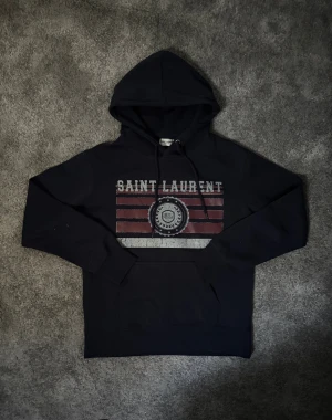 Saint laurent hoddie - Säljer nu denna snygga saint Lauren hoddie, tröjan är i jättefint skick då den aldrig är använd✅ • Storlek S men sitter mer som XS (mått finns på sista bilderna) (Hör gärna av er vid frågor🙌🏼) , vet ej om den är äkta