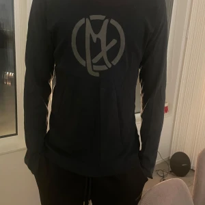 Mexx tröja  - Säljer en svart långärmad tröja från Mexx med stor logga framtill. Tröjan har en klassisk passform och är gjord i mjuk bomull, perfekt för dig som gillar enkel och stilren design. Passar till allt och är riktigt skön att bära.
