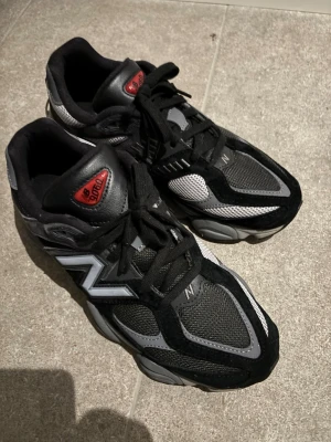 New Balance 9060 svarta sneakers - Snygga New Balance 9060 sneakers i svart och grått. Perfekt för dig som gillar streetwear och vill ha en modern look. Strl 43 nypris runt 2200kr, används typ 2ggr. 