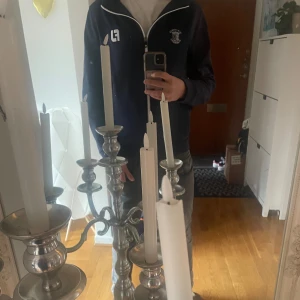 St Andrews GolfTröja - Säljer en mörkblå golfhooide från FootJoy med vit dragkedja och logga på bröstet. Jackan har huva, långa ärmar och broderad text 'Old Course St Andrews'.  Pefekt för en dag på golfbanan. I perfekt skick