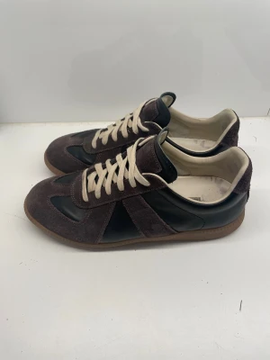 Maison Margiela  - Säljer nu ett par riktigt feta Masion Margielas, färgen svart och brun och storleken 44 men sitter lite lite mindre i storleken. Perfekt nu inför höst/vinter. Skriv gärna vid minsta fundering 