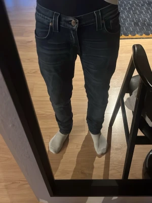 Mörkblå jeans från Nudie Jeans Co - Säljer ett par mörkblå jeans från Nudie Jeans Co med klassisk femficksdesign och snyggt smal passform. Jeansen är tillverkade i bomull och har en stilren look med diskreta slitningar. Perfekta för dig som gillar en clean och modern stil.