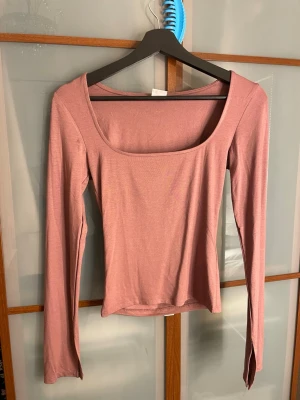 Rosa långärmad topp från Gina Tricot - Säljer en rosa långärmad topp från Gina Tricot, Elevated Basics. Toppen har en bred  urringning och är figurnära i modellen. Mjukt och stretchigt material som känns skönt mot huden. Perfekt att styla med jeans eller kjol.