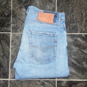 Replay jeans - Säljer ett par ljusblå skinny jeans från Replay med klassisk femficksdesign och läderpatch bak. Jeansen har en smal passform och är tillverkade i jeansmaterial med snygga slitningar framtill. Midja 41cm, längd 98cm. JAG SKICKAR EJ FLER BILDER NÄR JAG BÄR JEANSEN! för storleksguide hänvisar jag till måtten och för bättre inblick i passformen rekommenderar jag att googla på modellnamnet. Jeansen kan vara uppsydda utan att jag noterat det så kolla måtten noggrant :) s4  OBS SE DEFEKT PÅ SIDTA BILD.