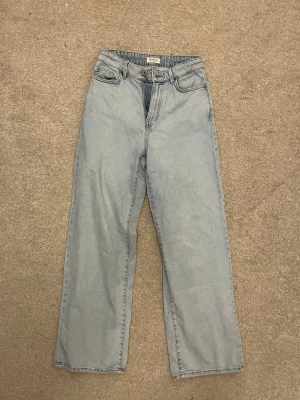 Raka jeans  - Ljusblå jeans från Lindex i rak modell med hög midja. Klassisk femficksdesign, bälteshällor och dragkedjegylf. Jeansen är tillverkade i bomull och har en avslappnad, tidlös look som passar perfekt till sneakers eller boots.