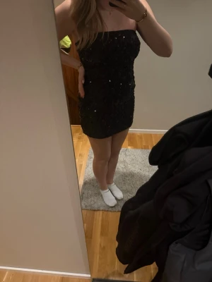 Svart paljettklänning  - Säljer nu min glitterklänning från Nelly. Klänningen har en tight passform och är axelbandslös. Vad jag har kunnat se finns den inte heller kvar på deras hemsida. Passar perfekt till nyår eller annat firande💗