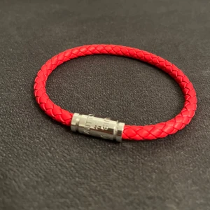 Lv Armband - Elegant rött L/V-armband med stilrent magnetiskt lås. En modern och exklusiv accessoar som passar både dam och herr. Lätt att ta på och av tack vare det magnetiska spännet.  En perfekt julklapp eller present till någon speciell – eller som en lyxig detalj till din egen stil.