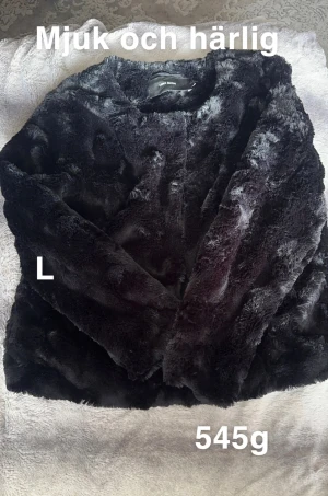 Svart pälsjacka från Vero Moda - Supermjuk svart pälsjacka från Vero Moda i storlek L. Jackan har en fluffig och lyxig känsla, perfekt för att hålla dig varm och snygg under kyliga dagar. Enkel design utan synliga knappar eller dragkedja, vilket ger en clean look.🌸 Sparsamt använd. Mjuk och go. Storlek L