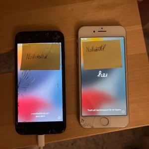 iPhone 7 (svart) - Svart Apple iPhone 7 säljes,  nollställd och fungerar, men har sprickor i skärmen och synligt slitage på baksidan. Perfekt som reservtelefon eller för den som kan byta skärm. Säljs i befintligt skick. Öppen för bud!