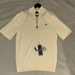 Vit merinoullströja från Morris - Vit stickad half zip tröja från Morris i 100% merinoull. Med snygg brun Morris logga inbroderad. ENDAST använd ca 3 gånger. Nypris 1799kr från Morris Stockholm