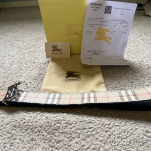 Rutig Burberry bälte med silverdetalj - Tja säljer ett burbeery bälte som är äkta, ändå bra skick med lite skador, kolla igenom alla bilder för att se allt du får med.  Köpte det för 3800 som ni kan se på bild 5 Hör av er vid funderingar. Mitt pris 1199