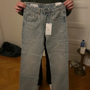 Ljusblå wide leg jeans  - Säljer ett par ljusblå jeans från Zara i modellen wide leg. De har klassisk femficksdesign, raka och breda ben samt hög midja. Jeansen är tillverkade i jeansmaterial och har snygga ljusa tvättade detaljer. Perfekt för dig som gillar en avslappnad och trendig look. Dom är helt nya och aldrig använda 