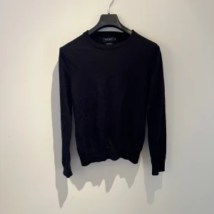 Blå merinoullströja från Riley - En stilren svart tröja från Riley i mjuk merinoull. Klassisk rund halsringning och långa ärmar, perfekt för lager-på-lager. Enkel och clean design som funkar till allt. Snygg passform och skön känsla mot huden. Inga defekter, hör av er vid frågor eller för fler bilder