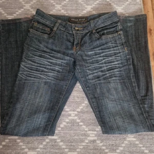 Mörkblå May Jeans med broderade fickor - Snygga mörkblå jeans från May Jeans med coola broderade detaljer på bakfickorna och slitningar framtill. Klassisk femficksmodell med raka ben och kontrastsömmar. Perfekta för dig som gillar en avslappnad men ändå stilren look.