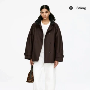 Brun oversized jacka från Arket - Mörkbrun slutsåld jacka från Arket. Säljer då jag råka köpa två stycken så tänkte kolla om det finns intresse! Jackan är oöppnad i paketet. Står såhär i beskrivningen på hemsidan: Fodrad bomullsjacka med ståkrage i manchestertyg och avtagbar vindslå. Raglanärmar, flikar med knappar vid ärmsluten och passpoalfickor. 