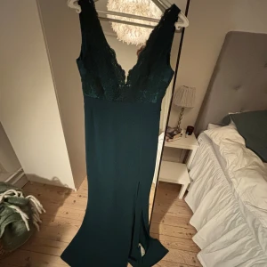 Mörkgrön balklänning med spets - En mörkgrön balklänning med spets och slits. Passar til bal, bröllop, sittning mm. 