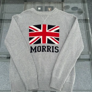 Titel: Morris stickad tröja grå L med Union Jack - Stickad tröja från Morris i storlek Large. Färg: Grå Detalj: Union Jack-flagga framtill + Morris-logga. Skick: Mycket bra, knappt använd.  Perfekt för dig som gillar klassisk preppy stil med brittisk touch. 