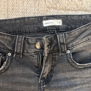 LOWWAIST Bootcut svarta jeans från GINA TRICOT Perfect Jeans - Snygga svarta bootcut jeans från Gina, Perfect Jeans i storlek 34. Jeansen har klassisk femficksdesign, dragkedja och knapp framtill samt bälteshällor. Materialet är jeans med en tvättad look som ger en cool vibe. Perfekt för dig som gillar lite vidare ben. Tveka inte på att höra av dig vid frågor eller intresse!
