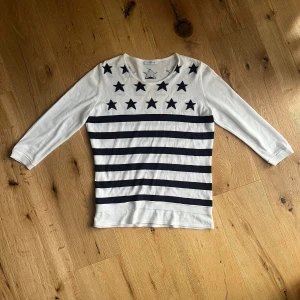 Tröja - Tröja med trekvatsärm och mörkblå stjärnor och ränder. Köptes secondhand så vet inte hur ofta den används men den har inga defekter. Säljer den då den inte är min stil längre.