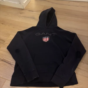 Mörkblå Gant hoddie 10-12 - En mörkblå Gang hoddie som jag har haft i ungefär 2-3 år tyvärr så är den sliten på armbågarna.