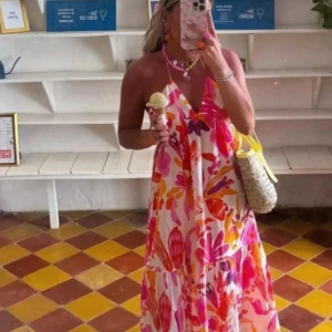 Blommig långklänning från Zara - Klänning från Zara som är halterneck. Bomull. Är liten i storlek passar storlek s eller liten m. 