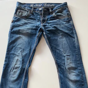 Blå jeans från R-Neal Denim - Snygga blå jeans från R-Neal Denim med snygga  slitningar. Storlek L32/W31 . Skit snygga, men tyvärr blivit för små för mig. Jeansen har raka ben och normal passform, det är ett litet hål i byxorna som syns på en utav bilderna, tänkte laga men har inte hunnit tyvärr. Hör av dig om du har någon fråga eller fundering. Mvh/Oliver
