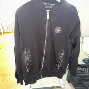 Svart bomberjacka från Philipp Plein - Svart bomberjacka från Philipp Plein med dragkedja, dödskalle på baksidan (några pärlor har lossnat) skick 7/10, inga fläckar eller hål men några pärlor har lossnat. Size L. Om du har fler frågor eller är intresserad, skriv privat