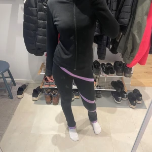 Svart fleece sett med strass - Svart fleece sett med hel dragkedja framtill och långärmad design med hål för tummarna. På ryggen finns ett stort strassmotiv av en konståkare. Perfekt för dig som gillar sportig och snygg stil. Den kostar från början 1300 ungefär 