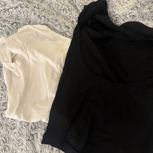 Svart och vit basic t-shirt med öppen rygg duo - Två klassiska t-shirts i svart och vitt med öppen rygg , båda med rund hals och kort ärm. Perfekta att matcha med jeans eller kjol. Mjukt material som känns skönt mot huden.