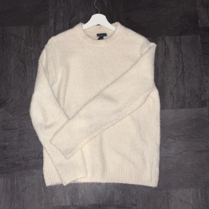 Vit stickad tröja från H&M - Mysig vit stickad tröja från H&M i storlek S. Tröjan har en rund halsringning och ribbade muddar vid ärmslut och nederkant. Regular fit och långärmad, perfekt för kyliga dagar. Enkel och clean look som funkar till många stilar.