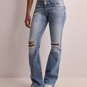 Ljusblå jeans från Nelly - jag säljer dessa ljusblåa lågmidjade jeans från Nelly, de sitter bra o e bekväma , mycket använda men inga större skador. Strl 32, original pris 750kr.