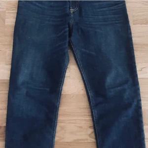 Mörkblå jeans från Diesel, modell 2005 - Snygga mörkblå jeans från Diesel, modell 2005 D-Fining. Klassisk femficksdesign med kontrastsömmar och diskret Diesel Industry-märke på fickan. Jeansen har rak passform och är tillverkade i slitstarkt denimtyg.