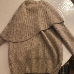 Beige stickad tröja River Island - Säljer en beige stickad tröja från River Island med lång ärm och ribbad struktur. Tröjan har en unik omlott-detalj över axlarna som ger en cool och trendig look. Perfekt för dig som gillar stilrena och mysiga plagg. Endast använd 2 gånger, passar både S & M. Pris kan såklart diskuteras! Köpt för 900kr