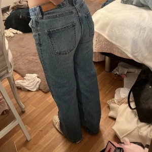 Blå wide jeans från Wera, strl 152 - Säljer ett par blå jeans från Wera i modellen wide. De har klassisk femficksdesign, raka och breda ben samt normal midja. Jeansen är tillverkade i jeansmaterial med snygg tvätt och kontrastsömmar. Perfekta för dig som gillar avslappnad stil.