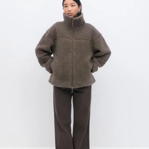 Brun teddyjacka med dragkedja - Säljer en brun teddyjacka med hög krage och hel dragkedja framtill. Jackan har en loose passform och är tillverkad i mjukt fleece-material som ger en mysig vibe. Perfekt för kyliga dagar och har långärmade ärmar. Jackan är enkel och stilren utan mönster. Endast använd en gång men köpte två färgen och får inte användning av denna tyvärr