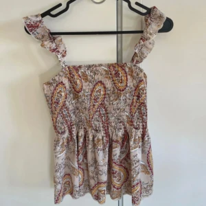 Söt topp med mönster  - En topp med mönster i strl M. Mycket bra skick. Den har resår upptill! Använd en gång.