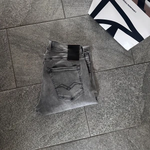 Replay Grover Hyperflex grå jeans - Säljer ett par grå Replay Grover Hyperflex jeans med klassisk femficksdesign och snygga detaljer på bakfickan. Jeansen har rak passform och är tillverkade i stretchigt denim för extra komfort. Perfekta för dig som gillar stilrena och bekväma jeans. Strl 29/32 men uppsydda till 29/30 eller 29/28