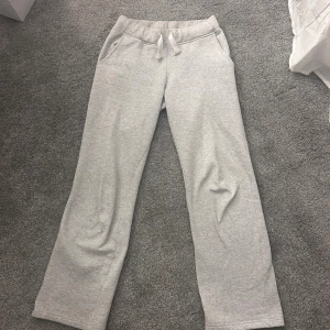 Grå mjukisbyxor med snörning - Ljusgrå mjukisbyxor med raka ben och snörning i midjan. Byxorna har två sidofickor och är tillverkade i mjukt bomullsmaterial, perfekta för en avslappnad stil. De är från russe merch och är i storlek S, innerbenslängden är 70cm och är lite förkorta för mig (1,79). ❣️