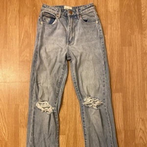 Ljusblå ripped jeans från Abrand - Säljer ett par ljusblå jeans från Abrand med raka ben och snygga slitningar på båda knäna. Klassisk femficksmodell med hög midja och använd max tre gånger, har inte stryck järn så därför ser dom kanske inte så fin ut på bilen men jätte fina på storlek 23 är som 32 typ 