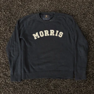 Morris tröja  - Marinblå stickad tröja från Morris med broderad logga i vitt över bröstet. Skick 8/10. Sjukt snygg och passar perfekt nu till hösten!