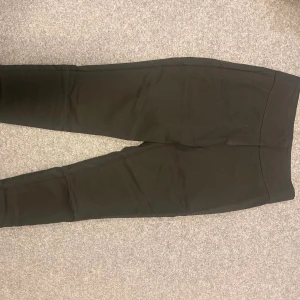 Svarta leggings med hög midja - Säljer ett par svarta leggings med hög midja. De är tighta och har en enkel, stilren design utan synliga detaljer. Perfekta för en clean och bekväm look.