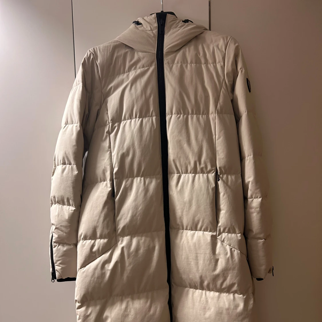 Beige lång dunjacka från Tenson